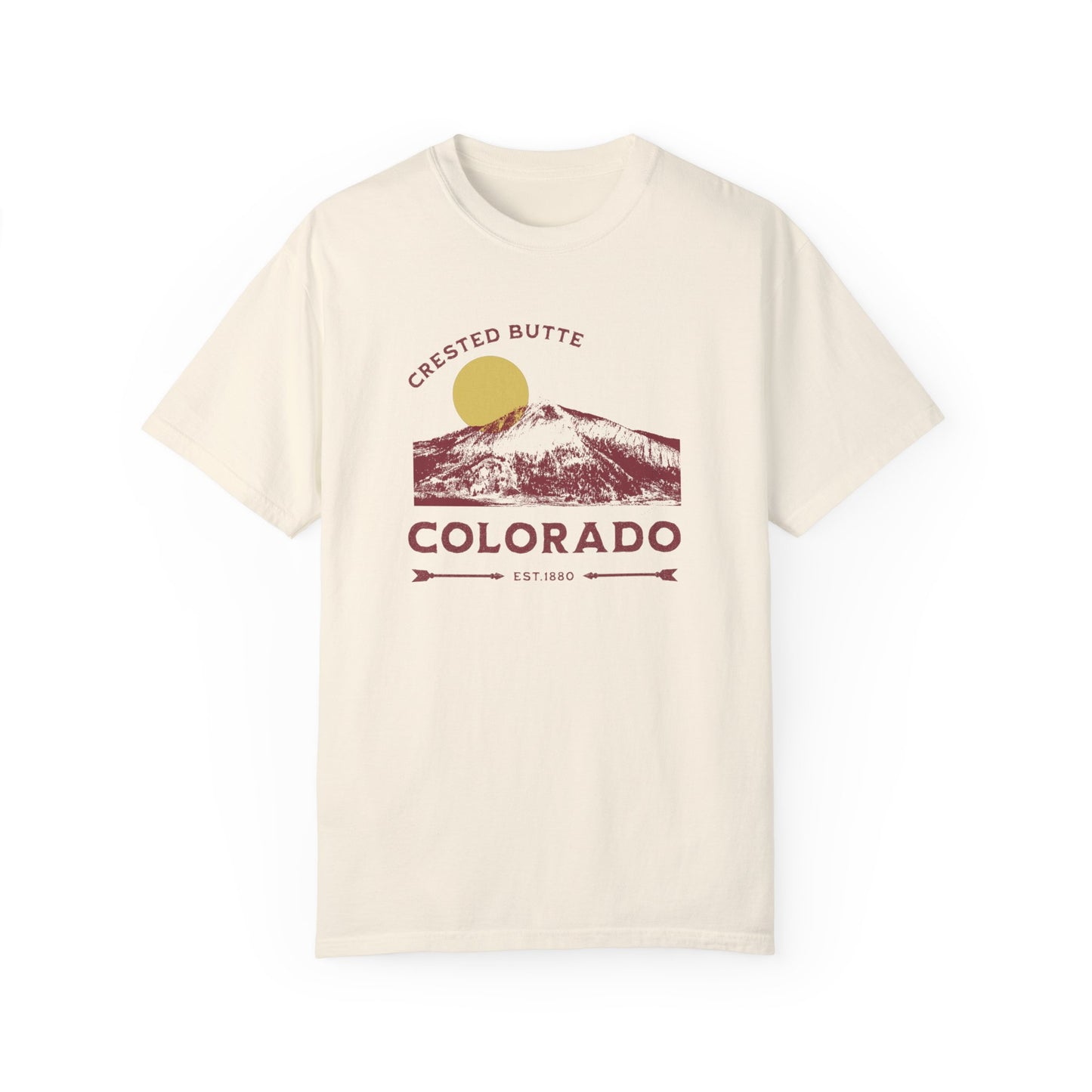 A beige t-shirt with a graphic illustration of Mt. Crested Butte and the text 'CRESTED BUTTE COLORADO' on the front.