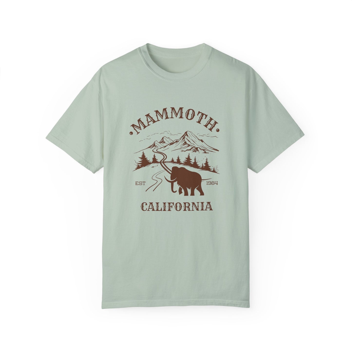 A green t-shirt featuring a mammoth silhouette with a ski mountain backdrop and the text 'MAMMOTH CALIFORNIA'.