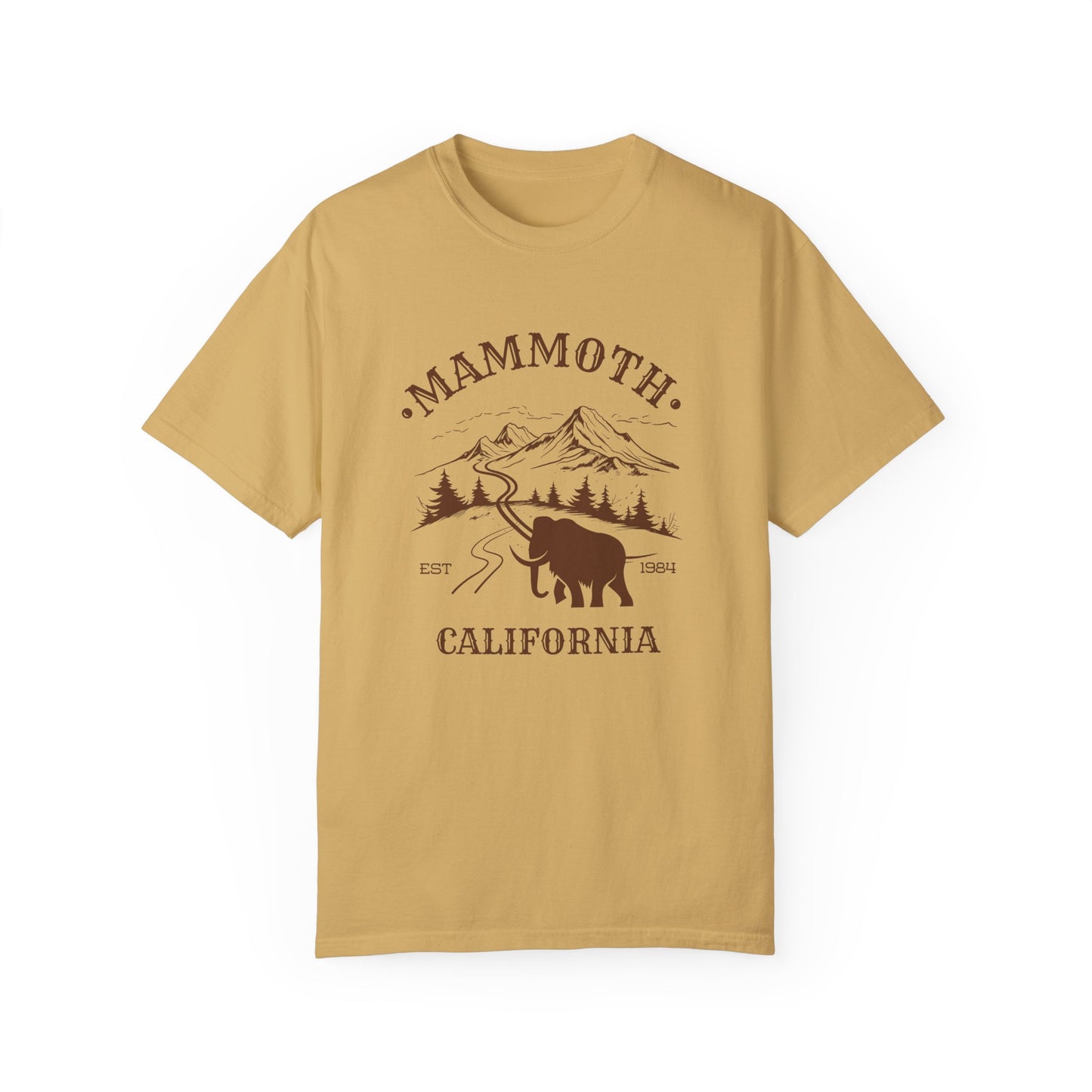 A mustard yellow t-shirt featuring a mammoth silhouette with a ski mountain backdrop and the text 'MAMMOTH CALIFORNIA'.