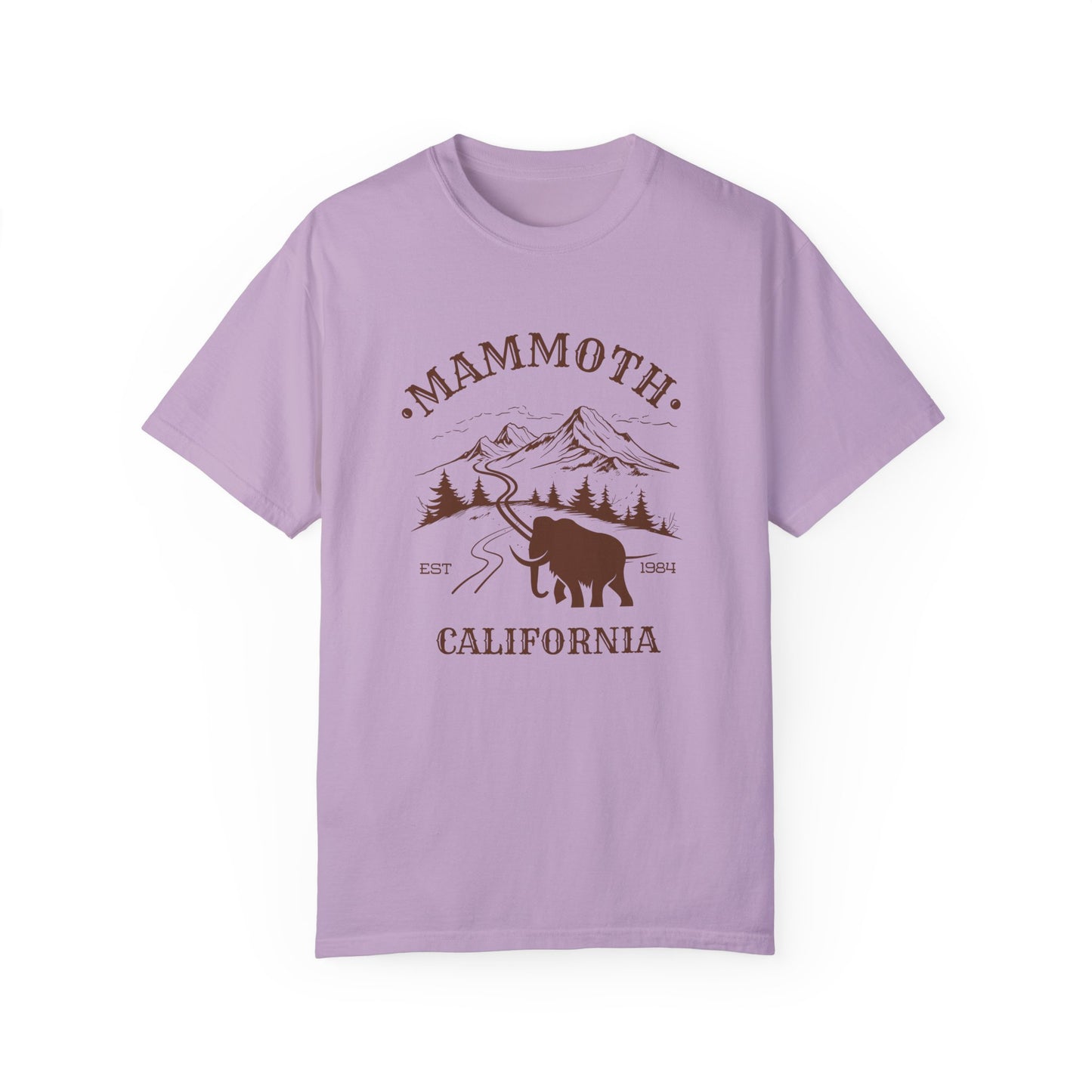 A light purple t-shirt featuring a mammoth silhouette with a ski mountain backdrop and the text 'MAMMOTH CALIFORNIA'.