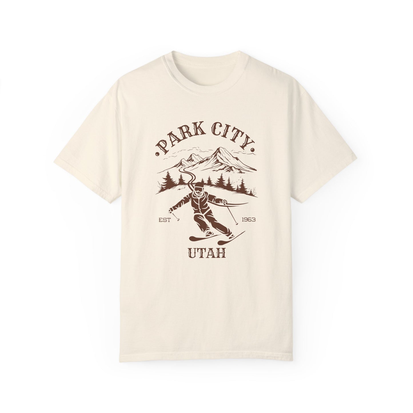 A beige t-shirt featuring a skier silhouette with a ski mountain backdrop and the text 'PARK CITY UTAH'.