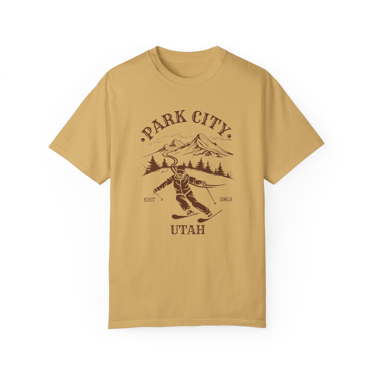 A mustard yellow t-shirt featuring a skier silhouette with a ski mountain backdrop and the text 'PARK CITY UTAH'.