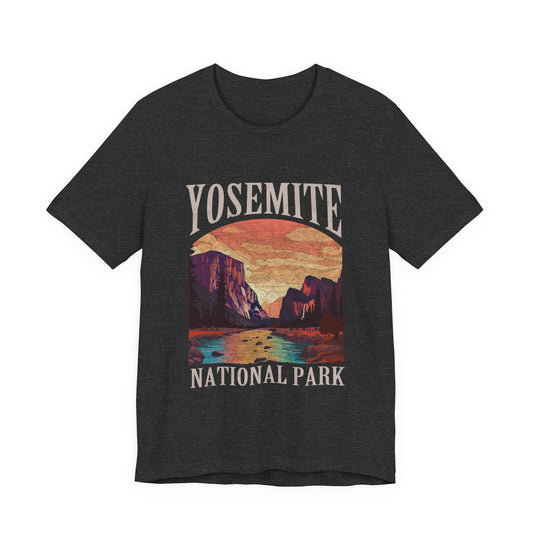 A dark heather gray t-shirt featuring a colorful graphic print of Yosemite National Park with a sunset landscape and cream-colored text.
